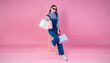 Portrait of happy beautiful shopaholic asian woman carry shopping bags, winter fashion sale model Asia girl with copy space, outlet department store advertising concept isolated pink banner background