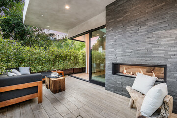 a view of the backyard with a fireplace and wooden furniture