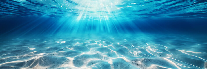 Wall Mural - A serene underwater view with sunbeams illuminating the sandy ocean floor through clear blue water.