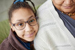 Close up of young African American girl leaning on grandmothers shoulder and looking at camera copy space