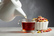 Herbal tea is poured into a mug.