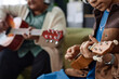 Close up of unrecognizable African American girl playing ukulele during music class indoors copy space