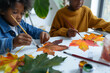 © elinorka - African-American children are drawing with paint autumn leaves.