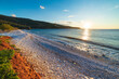 Sunset view beautiful beach and water bay in the greek spectacular coast line. Turquoise blue water unique white pebbles, Greece summer top travel destination Mani peninsula Peloponnese