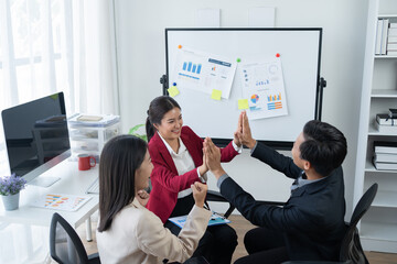 Wall Mural - Group of young business people discussing business while working by using line chart  and laptop in the office together 