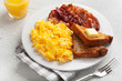 traditional scrambled egg breakfast with bacon and toast