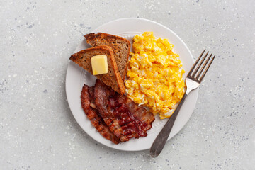 traditional scrambled egg breakfast with bacon and toast