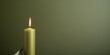 Olive background with white thin wax candle with a small lit flame for funeral grief death dead sad emotion with copy space texture for display 