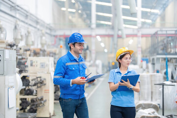 Canvas Print - In the dynamic environment of the industrial plant, the European male engineer and the Asian female engineer operate machinery, optimizing production for global market expansion.
