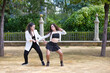 Couple of young women dancing to latin music: Bachata, merengue, salsa. The two girls do different postures dancing outdoors in the street. Latin dances and dance concept.