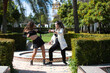 Couple of young women dancing to different types of Latin music and dance. The two girls do different postures dancing outdoors in the street. Latin dances and dance concept.
