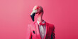 Stylish flamingo bird in a suit looking at the camera on a pink background, animal, creative concept