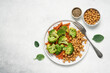 Healthy food broccoli, carrots and chickpeas on a plate top view on a white background with copy space