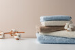 Stack of delicate colored cotton towels with cotton buds on a beige background