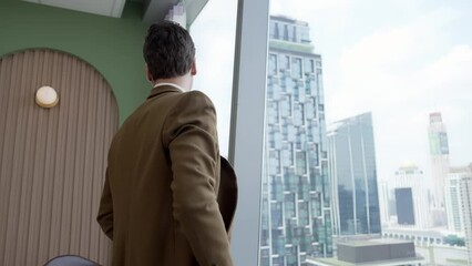 Wall Mural - Back view ambitious businessman standing in ornamented office gazing out window to cityscape skyline. Determination and business ambition drive business career toward to bright future