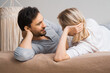 Image of young couple looking at each other, lay on bed. Blond woman with brunette bearded man in love, relationship, dating, happy family, waiting child concept.