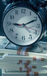 Business, investment, financial assets and liabilities, earnings, passive income concept. Clock with money.  Vertical image.