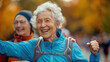 An old woman in her 70s is happy for finishing running or jogging tournament, while a peer lady celebrates with her. Active lifestyle for the elderly.