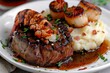 Surf and turf with lobster tail scallops mashed potato on white plate pan shot