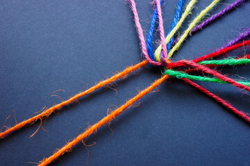 Wall Mural - orange thread connecting colored threads. teamwork and diversity.