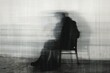 Silhouette of a man in a coat sitting on a chair in the rain