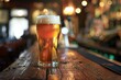 Glass of beer on wooden table in pub with bokeh background