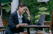 © PRIYO DWI SAPUTRO - Asian businesswoman has headache and feel tired in outdoor cafe.