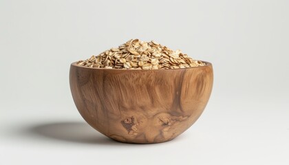 Wall Mural - Uncooked oat flakes in a wooden bowl on a white background represent vegan and healthy eating
