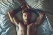 Handsome Tattooed Man Lying in Bed with Hands Behind Head