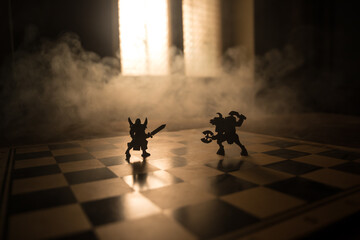 Wall Mural - Medieval battle scene with cavalry and infantry on chessboard. Chess board game concept of business ideas and competition and strategy ideas Chess figures on a dark background with smoke and fog.