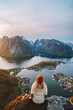Woman traveling in Norway hiking on Reinebringen mountain, girl enjoying sunset Lofoten islands aerial view summer active vacations solo traveler sightseeing outdoor healthy lifestyle adventure tour