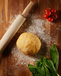 Homemade dough, salad, cherry tomatoes and rolling pin