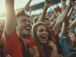 © David Irlweg - Junges Pärchen zeigt Freunde über den Sieg einer Fußballmannschaft. Fans beim Feiern ihrer Mannschaft.