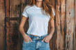 Young woman wearing bella canvas white shirt mockup, at dark wooden wall background. Design tshirt template, print presentation mock-up.