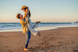 © EDER - copyspace Latina girl lifted in the air by boyfriend during romantic beach stroll