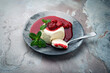Traditional quark mousse with rhubarb and raspberry compote served as close-up on a Nordic Design plate