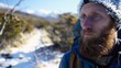 © Thanthara - Backpacker on a snowy path in Patagonia, close-up on frosty beard and icy blue eyes, wild, cold scenery