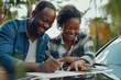 © KirKam - African American couple joyfully signing documents on the hood of a car, possibly purchasing a new vehicle.