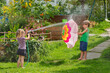 Children boy and girl enjoy a water fight outdoors in summer
