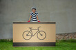 Boy in a safety helmet is perched on huge box with bike sign