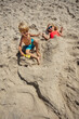 Joyful beach day for playful kids, having fun, prank with sand