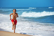 Teenage boy race on sunny seashore with beautiful azure back