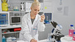 © Krakenimages.com - Intriguing glimpse into the world of science, beautiful young blonde scientist meticulously noting experiment observations while gazing at a test tube in a medically advanced laboratory.
