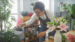 © Krakenimages.com - Young asian man watering plants in a flower shop, creating an inviting green interior.
