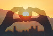 Hand shape heart in the city at sunrise 