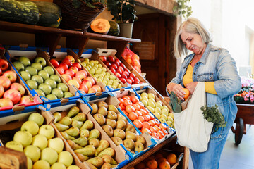 Latin senior woman shopping at farm market. Customer buying at grocery store. Small business concept