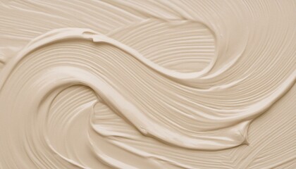 A swirl of a creamy beige substance spread in waves to create a background texture of quiet luxury concept.