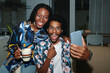 Excited Black man taking selfie with best female friend