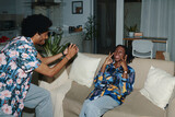 Fototapeta  - Black man photographing girlfriend at home