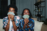 Fototapeta  - Funny young Black couple posing with playing cards